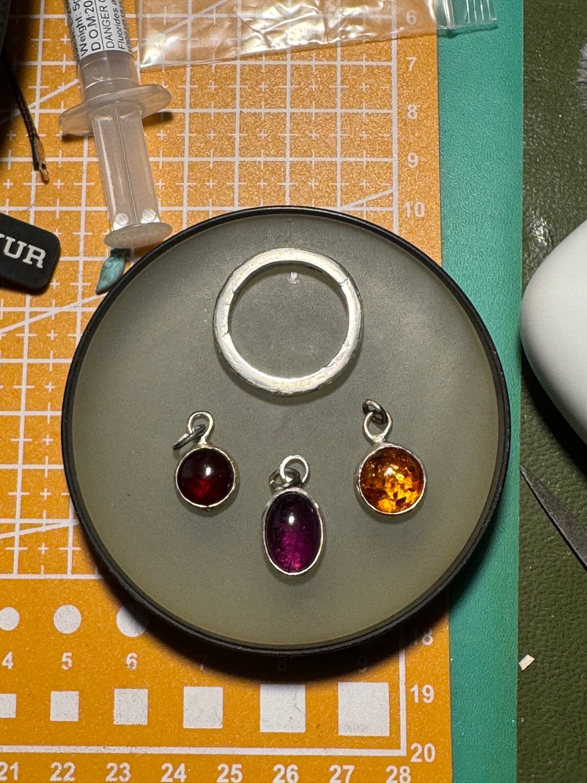 Handmade pendants and a ring on the workbench