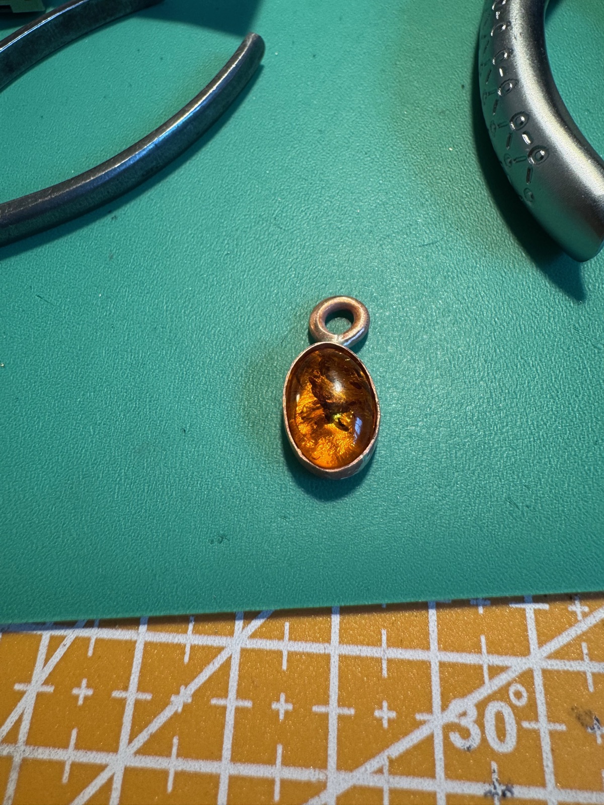 Honey-toned amber drop pendant set in copper