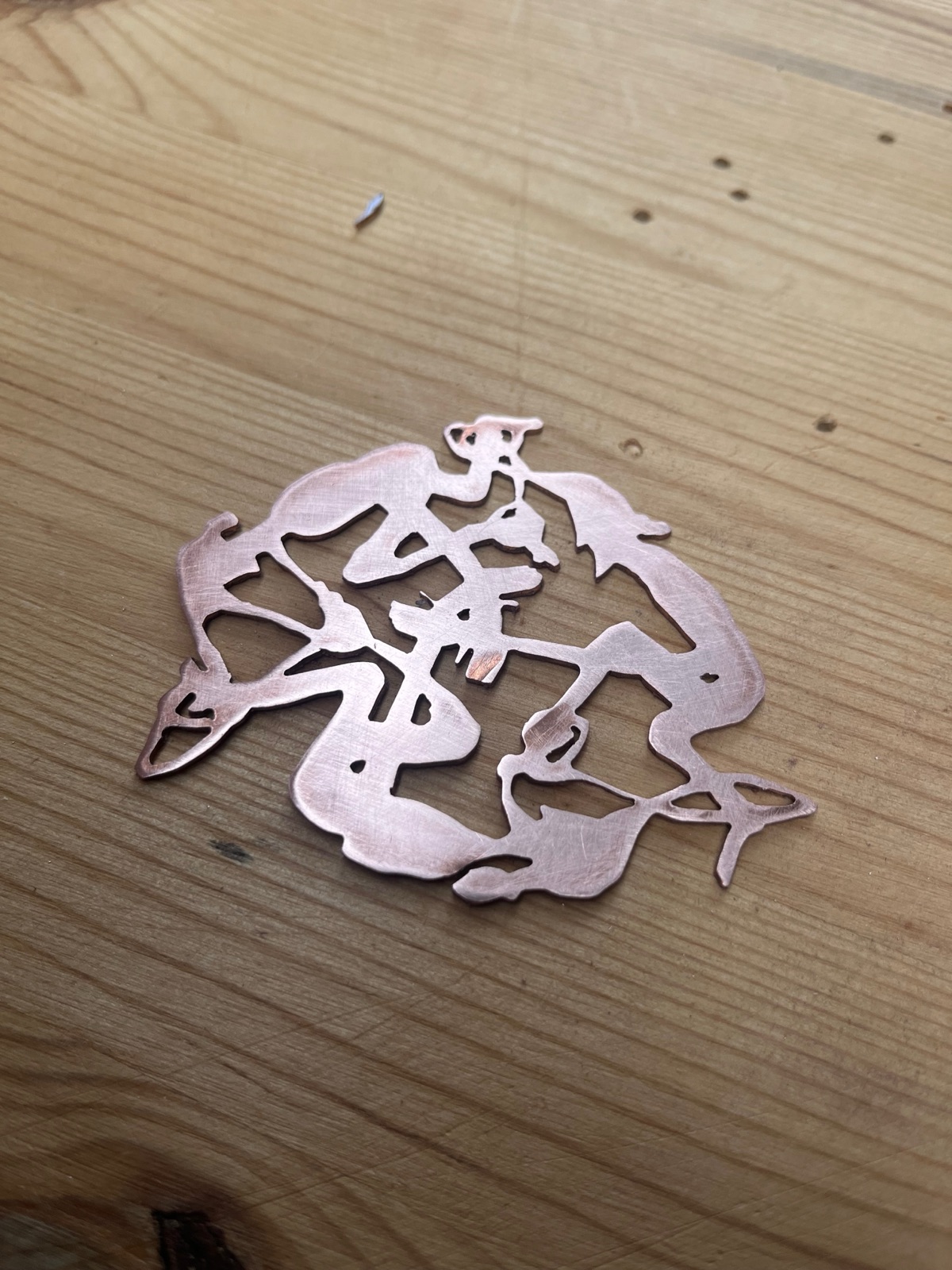 Intricate hand-pierced copper openwork pendant